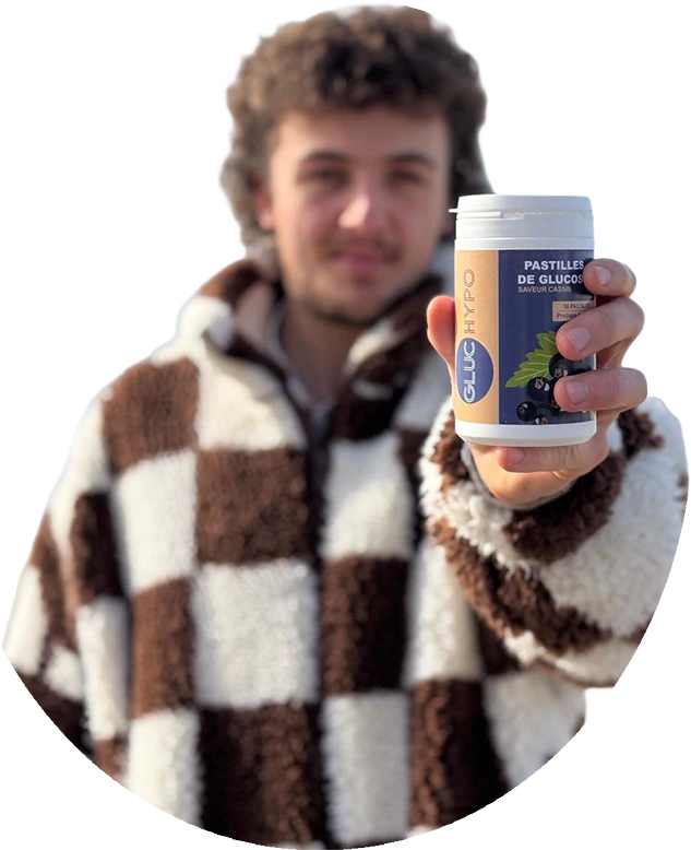 Jeune homme tenant une boîte de pastilles de glucose Gluchypo saveur cassis contre l'hypoglycémie