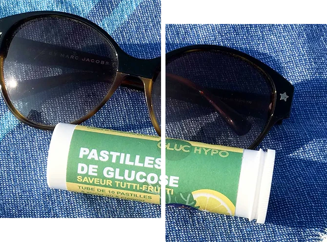 Tube de pastilles de glucose tutti-frutti Gluc Hypo et lunettes de soleil sur tissu bleu